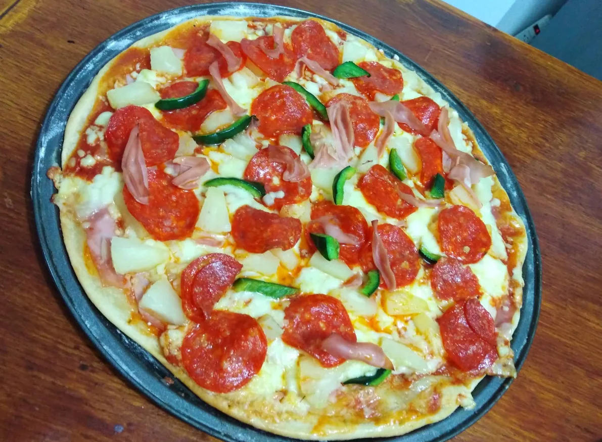 Pizza con pepperoni, jamón, piña y pimiento